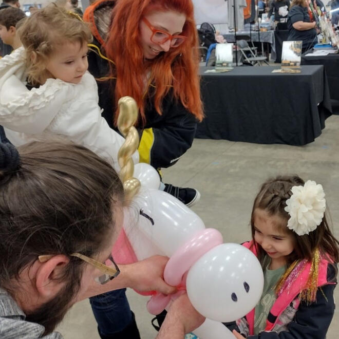 Tommy giving out a balloon animal at the County Fair