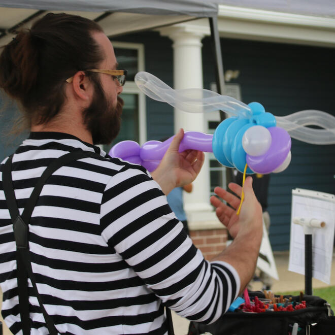 Tommy twisting a Dragonfly balloon