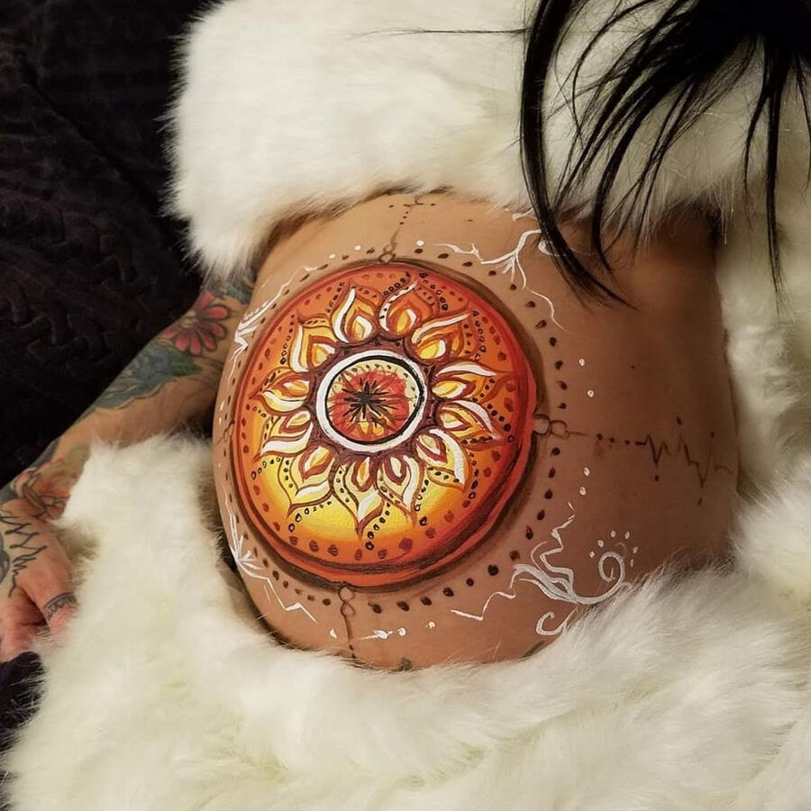 A pregnant belly, painted with a beautiful neutral toned mandala